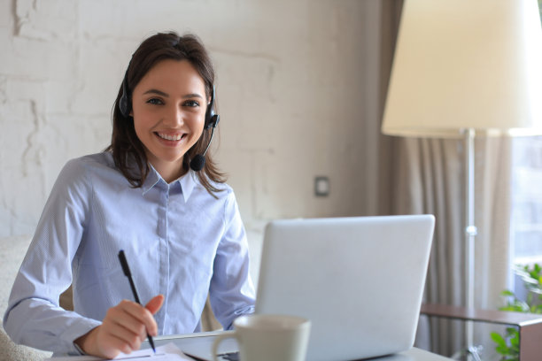 自由接线员与耳机和咨询客户从家庭办公室。图片下载