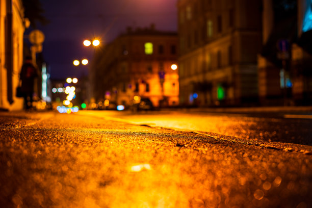 秋雨夜城。空无一人的街道上走着一个人。图片下载