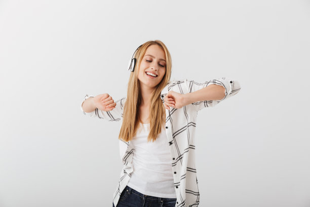 开朗的年轻随意的女孩用耳机听音乐图片下载
