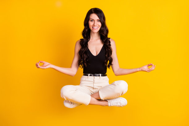 年轻开朗的女孩的全身照片快乐的积极的微笑莲花姿势冥想禅宗平静孤立在黄色的背景图片下载