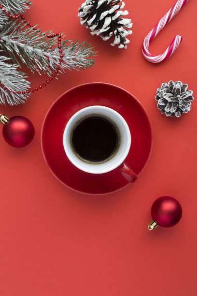 红色陶瓷杯里的黑咖啡和红色背景上的圣诞构图图片下载
