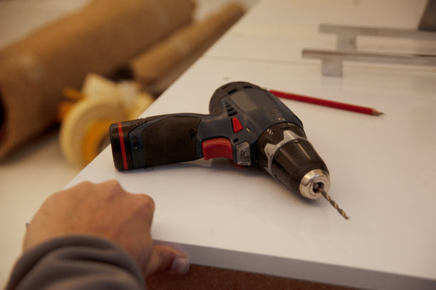 一个年轻人在车间里和钻头一起工作图片下载