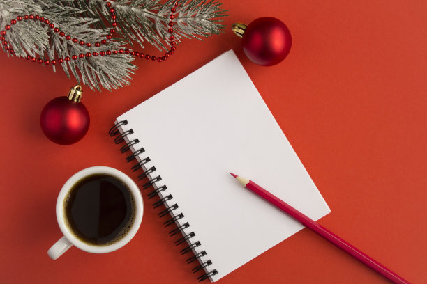 打开记事本，白色杯子里的黑咖啡和红色背景上的圣诞作文图片下载