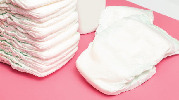 婴儿的背景。产品、购物、叠放一次性纸尿裤以粉色为背景。新生儿配件俯视图或平铺。图片下载