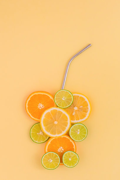 橘片、柠檬片和酸橙片，呈玻璃杯状，以橘色为背景。柑橘类果汁的概念。图片下载