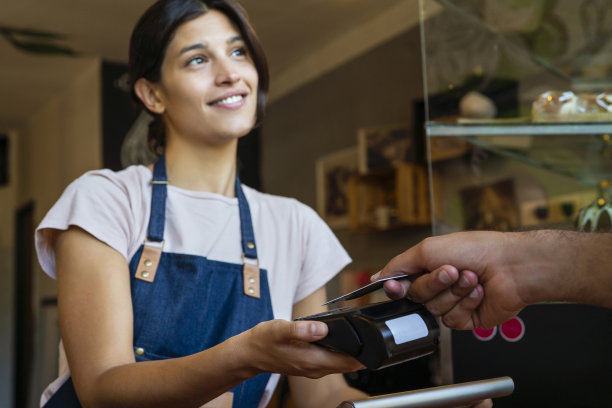 一个年轻的成年妇女在咖啡厅接受信用卡支付的照片图片下载
