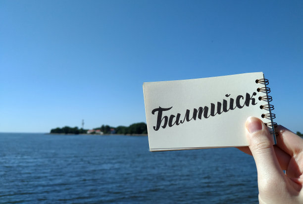 美丽的巴尔蒂斯克景色。在笔记本上以俄文书法题写“巴尔蒂斯克”。一览波罗的海。俄罗斯巴尔蒂斯克，2021年6月17日。——在笔记本上。移动摄影。图片下载