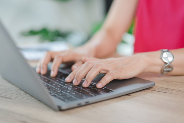 一位快乐的中年亚洲女商人，穿着休闲的休闲装在家工作，在电脑上查看电子邮件，在财务会计凭证上写作。商业库存图片图片下载