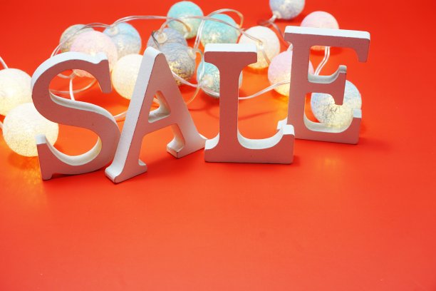 销售字母字母与棉球装饰在红色的背景图片下载