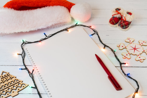 圣诞装饰用白纸写一个愿望或一封信给圣诞老人在白色的木制背景。图片下载