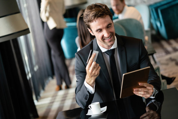 自信英俊的年轻商人在咖啡馆付款图片下载