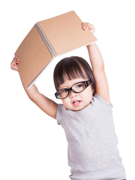 可爱的亚洲学步女孩戴眼镜阅读一本书孤立的白色背景与剪贴面具，教育家庭学校和回到学校的概念图片下载