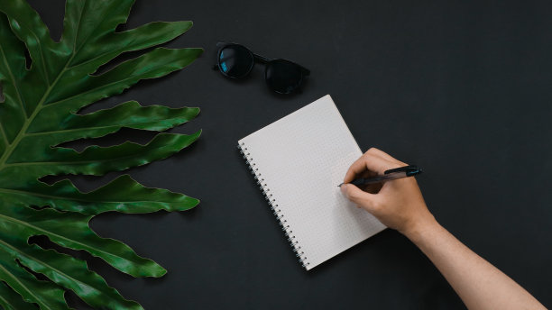 绿色的叶子和笔记本在黑色的背景图片下载