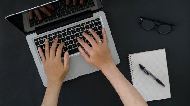 手持黑色背景的笔记本电脑图片下载