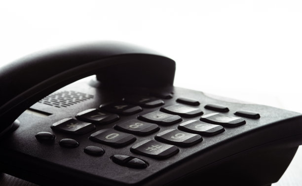 桌上有按钮的黑色座机。在白色的背景上。图片下载