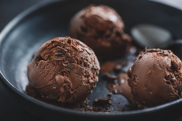 美味可口的巧克力冰淇淋与巧克力块在黑色的盘子图片下载