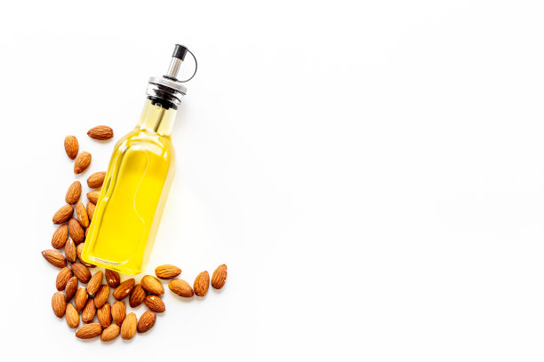 装在玻璃瓶中的杏仁油和杏仁。特级初榨精油图片下载