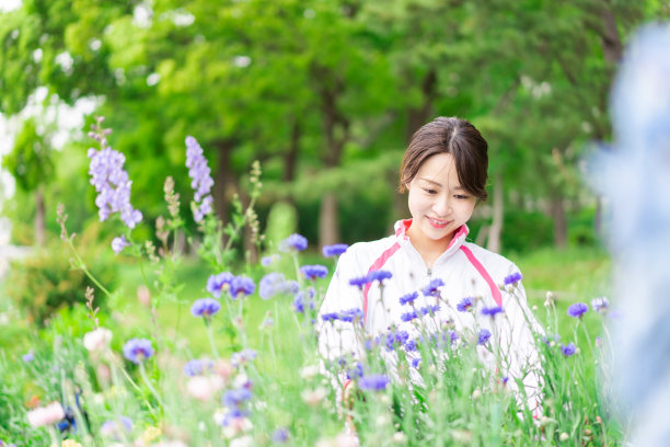 在花园里照料花朵的年轻女子图片下载