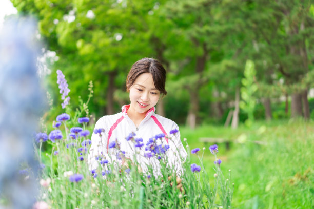 在花园里照料花朵的年轻女子图片下载