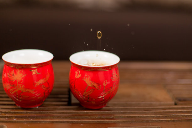 中国茶道。陶土制成的茶壶和木制背景的碗。图片下载