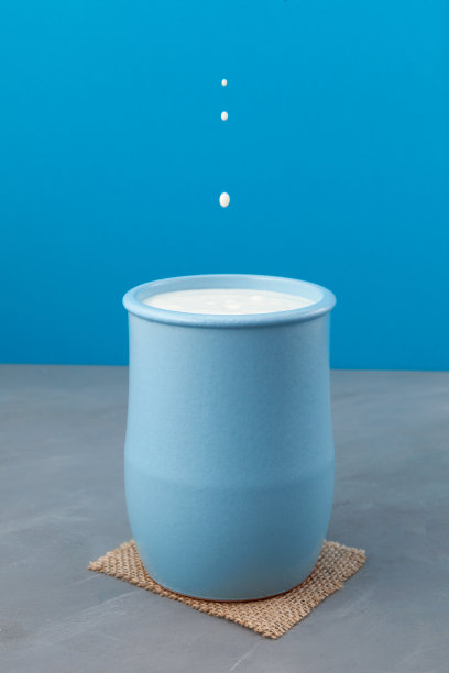 土耳其饮料艾兰或开菲尔浅蓝色陶瓷壶在蓝色背景。发酵的牛奶喝。减肥饮料。从酸奶酪乳。选择性聚焦，垂直方向，拷贝空间图片下载