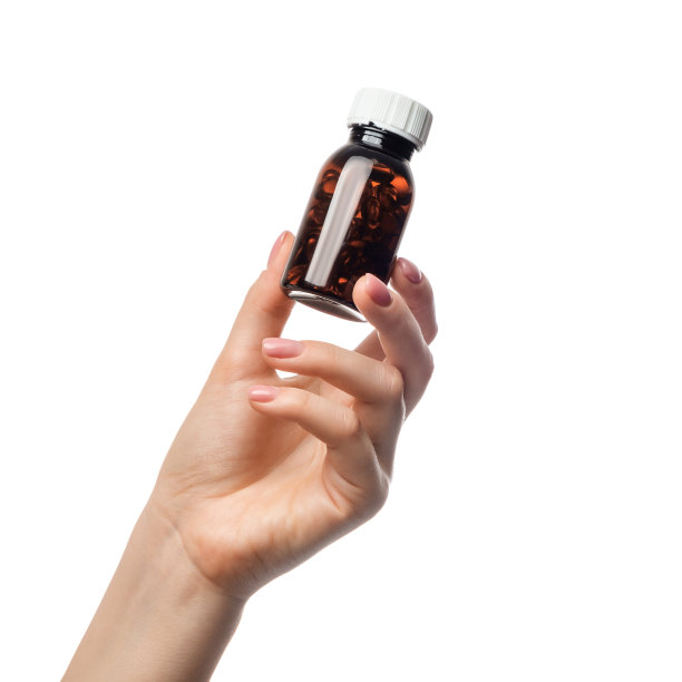 罐子里装满了药丸，胶囊在一个女人的手里。图片下载