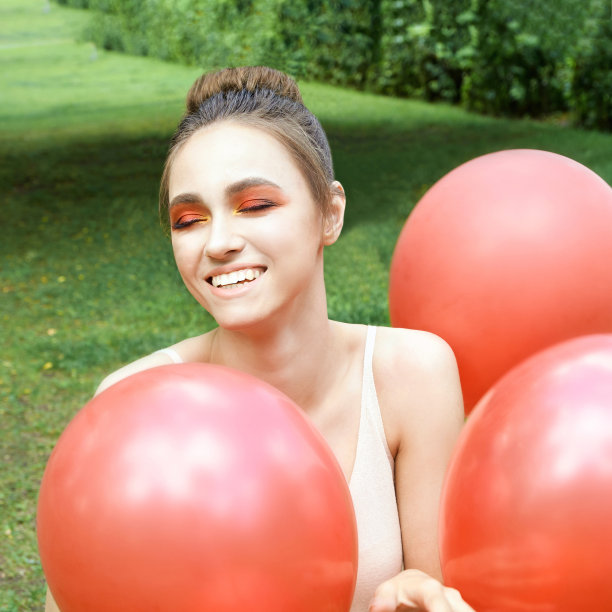 年轻漂亮，妆容鲜艳。户外绿色画像图片下载