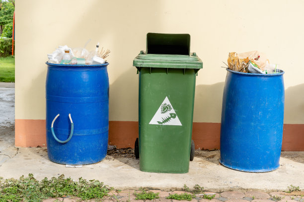 堆满城市生活垃圾的垃圾桶。蓝色和绿色垃圾箱，保护环境。塑料、纸张、玻璃分装，环保生活方式，保护环境。图片下载