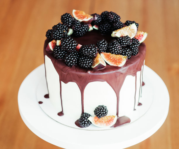 巧克力蛋糕浸在巧克力中，并用黑莓和无花果作装饰。节日糖果图片下载