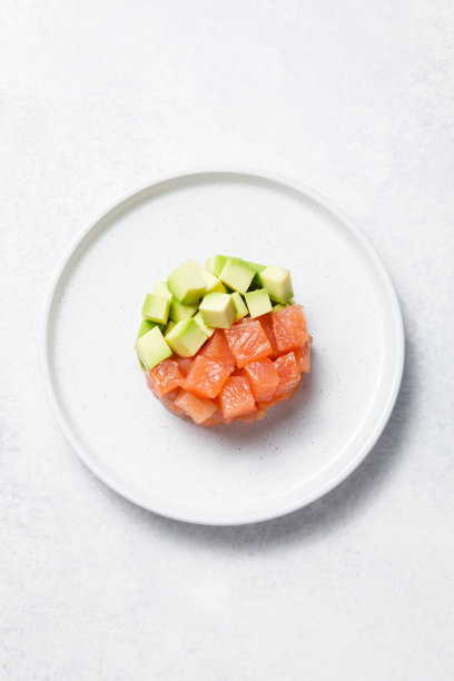 三文鱼鳄梨鞑靼在白色的石头桌子的背景。图片下载