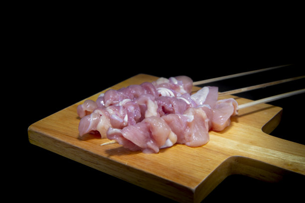 用竹签在黑色背景下烤鸡。为你的文本留出空间。图片下载