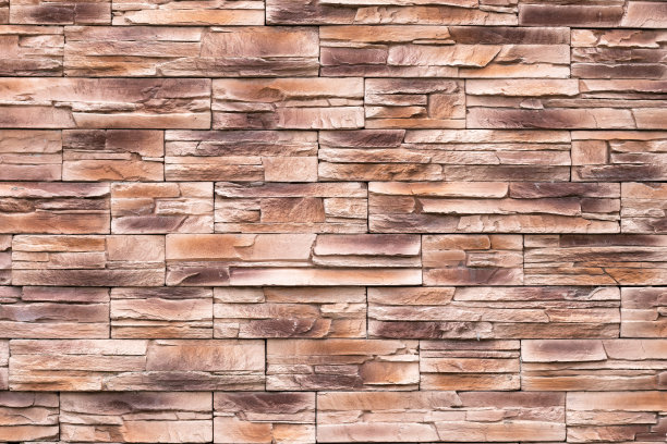 墙面纹理为褐色的石材，表面凹凸不平，底色为垃圾砖，图案抽象，岩石表面，粗糙的花岗岩。建筑立面。纹理背景，设计元素。复古砖。砌砖,砌筑图片下载