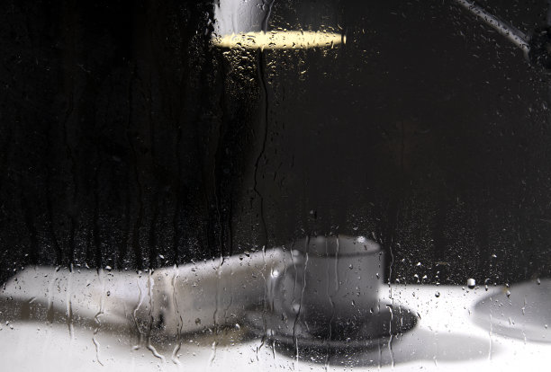 湿窗的特写，雨夜的概念。在窗边看书。翻开书，一杯茶，一盏灯图片下载