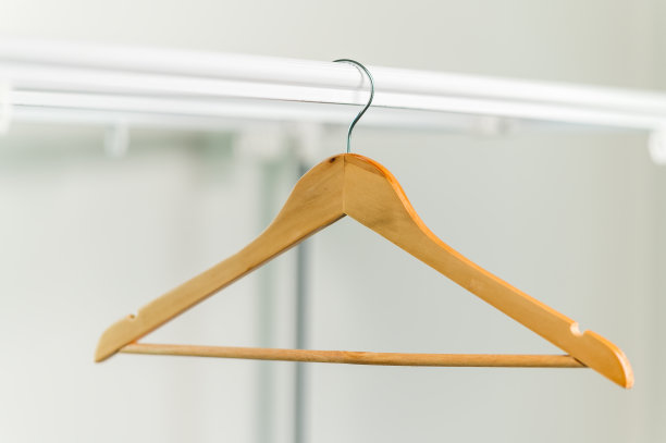 衣柜里的衣架上挂着一个空的木制外套衣架图片下载