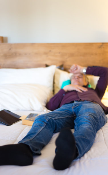 老人穿着衣服在床上打盹图片下载