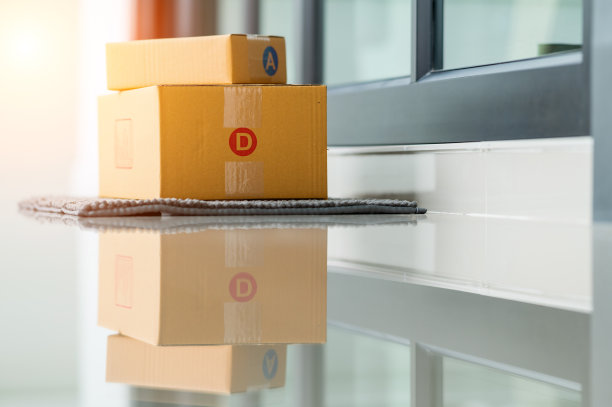 投递包裹的盒子放在家门口门口的擦鞋垫上图片下载