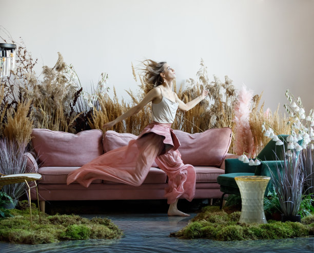 美丽的年轻女子在一个房间里，沙发在高高的草丛中图片下载