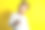 四岁的白人小男孩穿着白色衬衫站在黄色背景前拿着遥控器摆姿势，自信地看着镜头图片下载