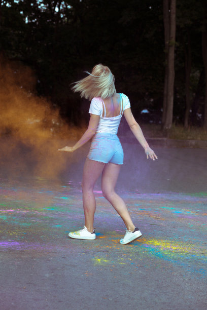 年轻漂亮的女人拿着爆炸的油漆庆祝胡里节图片下载