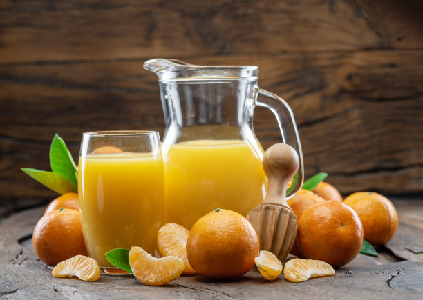 橙色的橘子水果和新鲜的橘子汁在深色的木头背景。图片下载