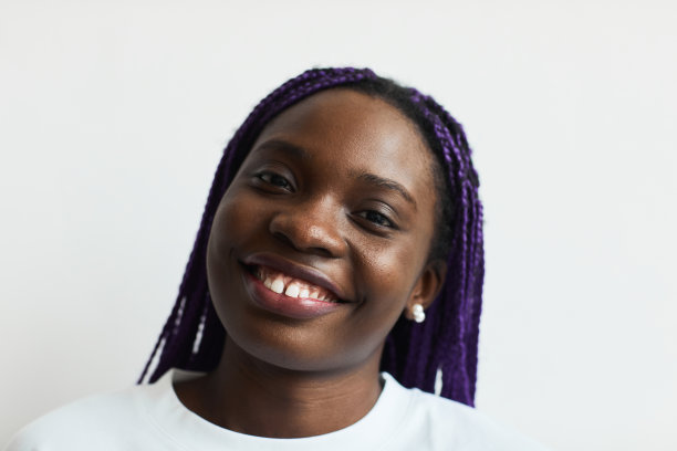 微笑的非洲裔美国妇女与紫色头发图片下载