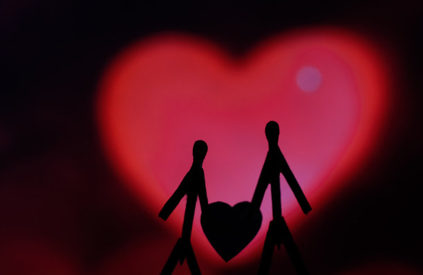爱的夫妻用火柴棍的概念。男性和女性靠在一起，背景是美丽的心形。火柴艺术摄影用火柴棒创造了这个人物。图片下载