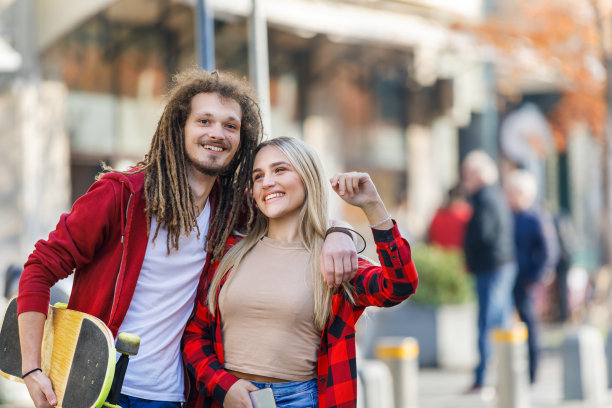 一个年轻夫妇的肖像谁是站在城市的街道上，试图赶上一个便车。图片下载