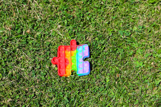 在绿色的草地上把它弄成拼图的形状。动力硅胶玩具变形的太阳热图片下载