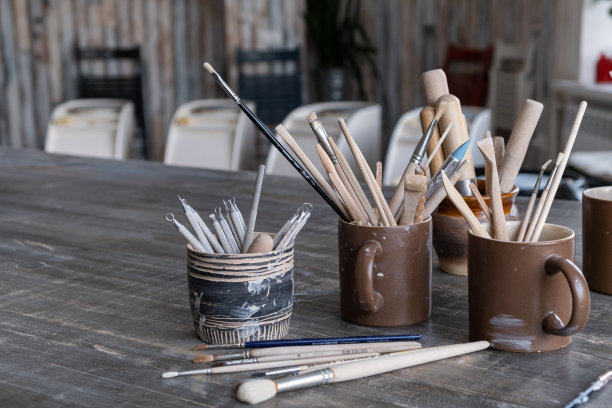 桌子上有带刷子的陶瓷杯子图片下载