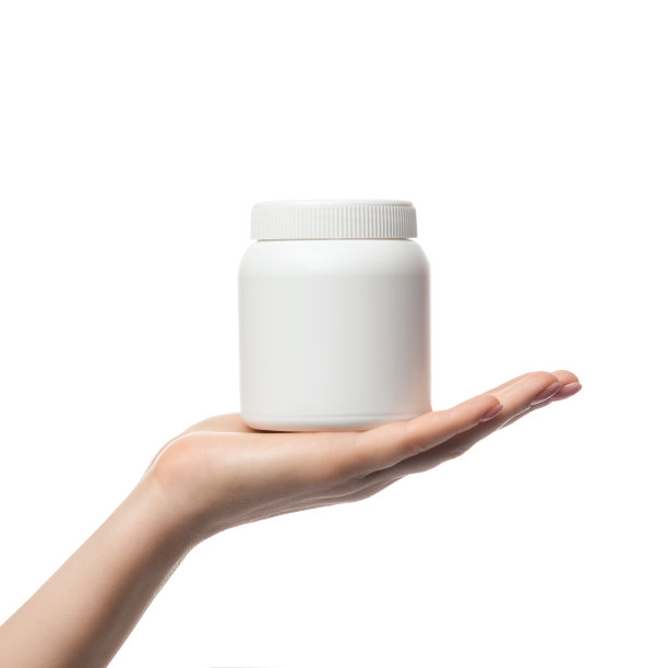 一个白色的塑料瓶，一个女人手里的容器。有广告或标识的空间。商业产品的模板。图片下载