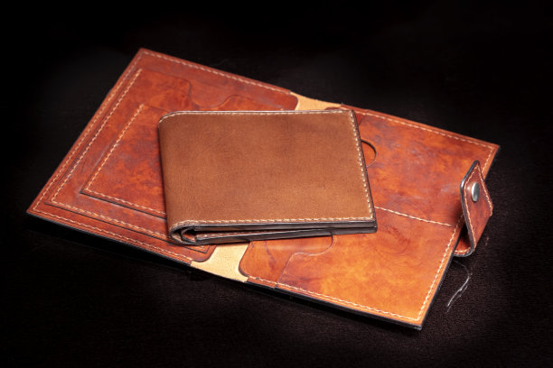 打开皮革棕色钱包与口袋在一个黑暗的背景。图片下载