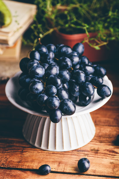 白色盘子上的深蓝色葡萄图片下载