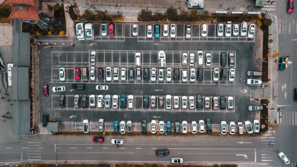 四川海螺沟著名旅游公园附近的收费停车场的上下鸟瞰图。垂直停放的车辆，不同类型的汽车，被街道包围图片下载