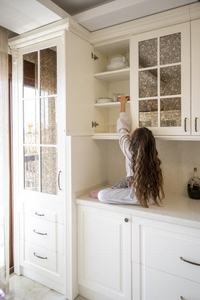 可爱的女孩爬上了厨房的台面图片下载